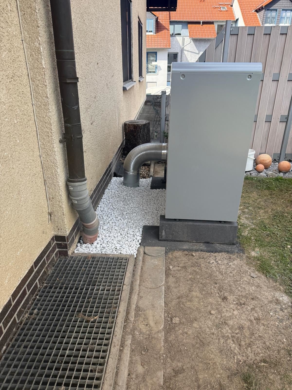 Außengerät der Wärmepumpe im Seitengang mit Kiesbett