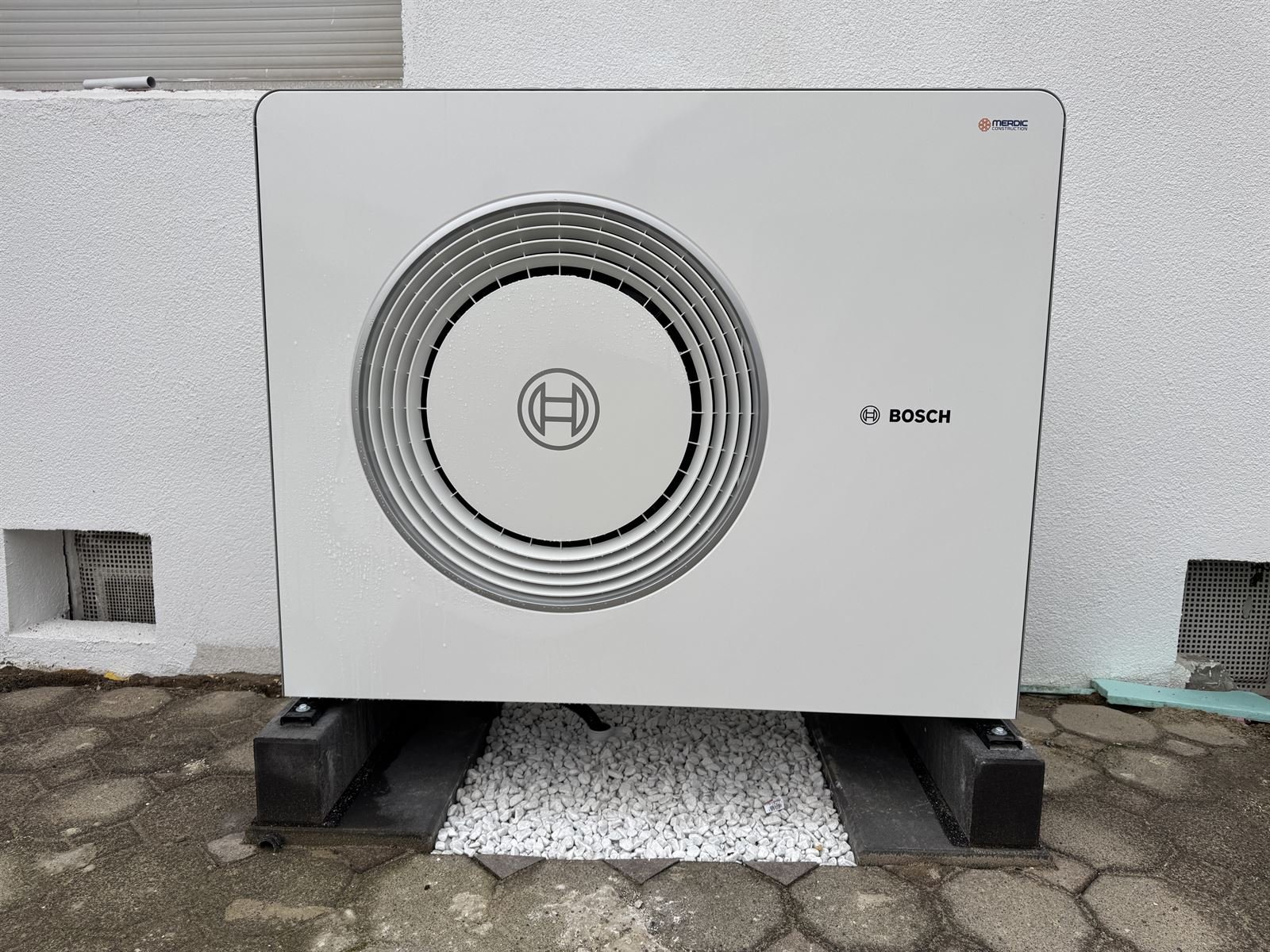 Bosch-Wärmepumpe vor einer weißen Hauswand in Löhne