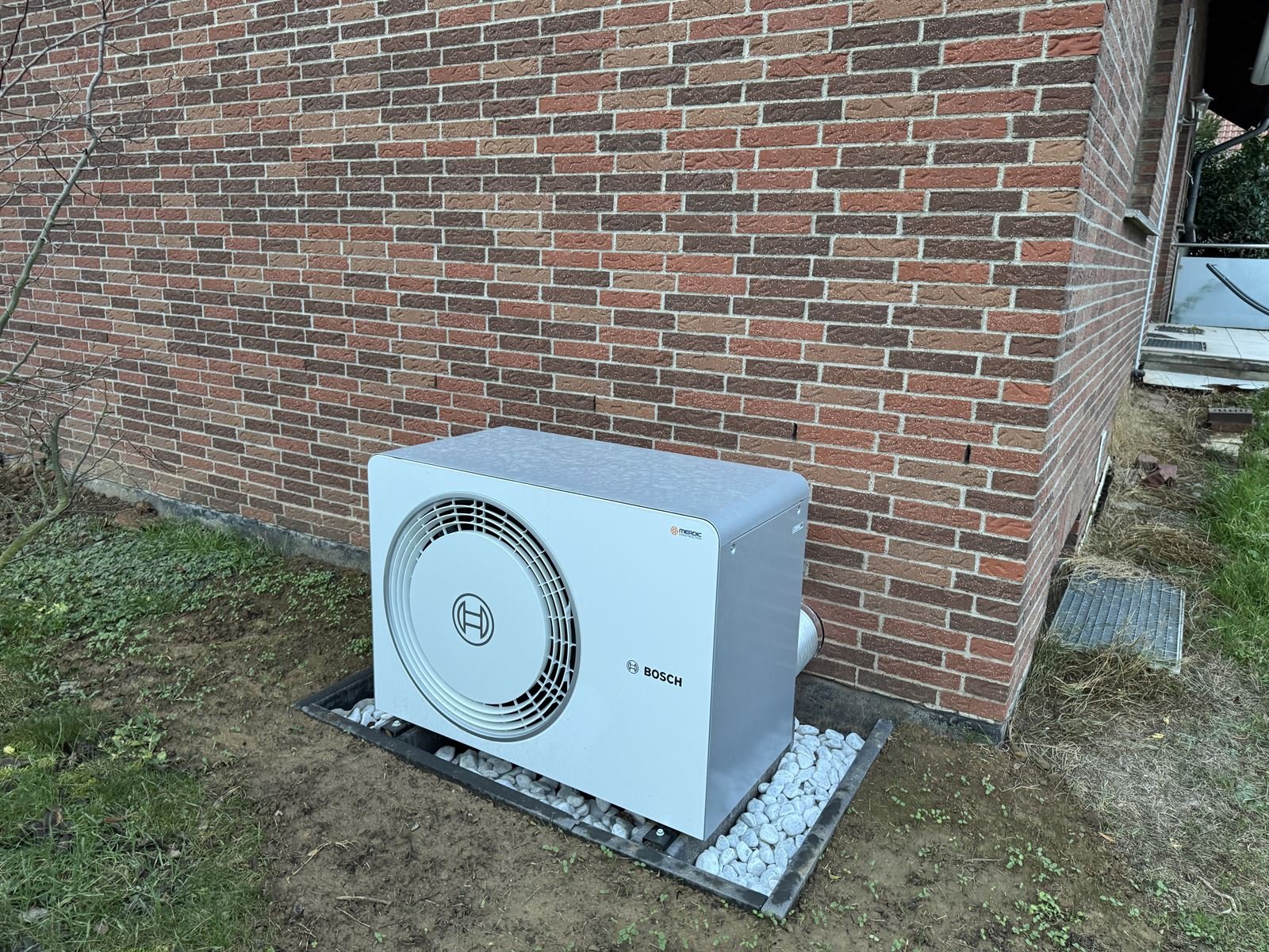 Bosch-Wärmepumpe auf Kiesbett an einer Klinkerfassade in Lohfelden