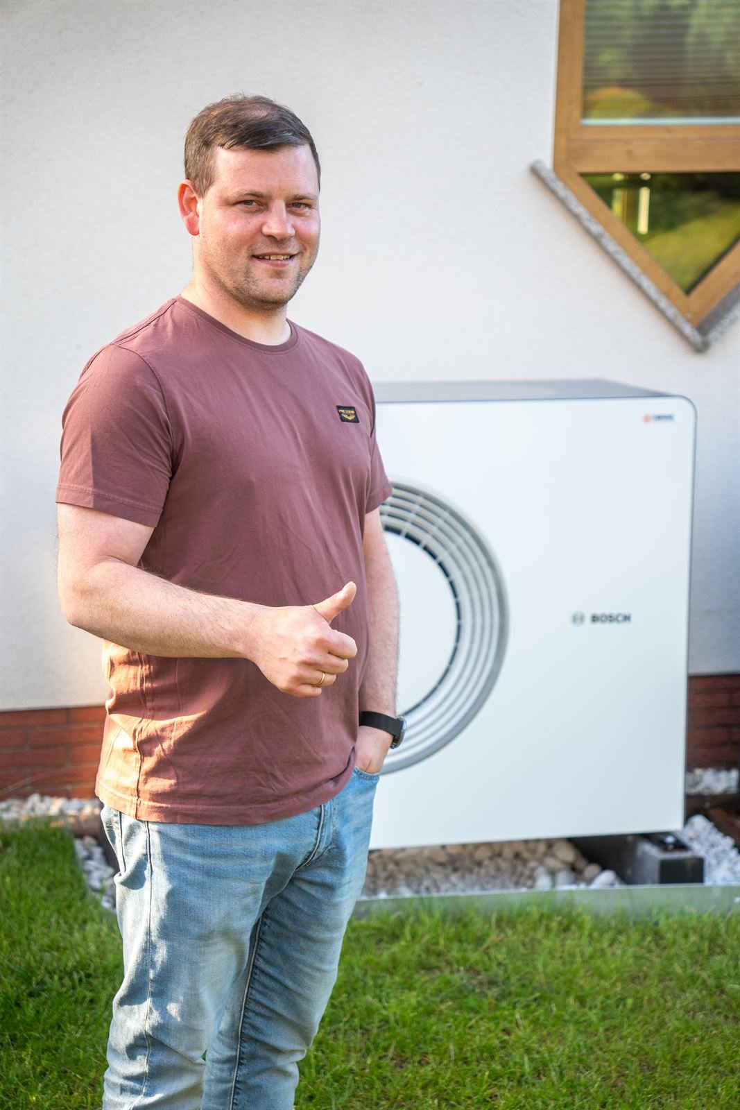 Phillip aus Melsungen neben seiner neuen Bosch-Wärmepumpe